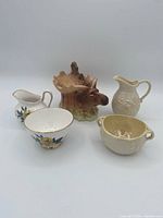 Group shot showing all five items: floral creamer, floral teacup, ivory sugar bowl, ivory creamer, moose planter