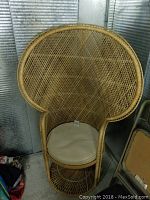 Vintage large wicker peacock chair photographed from the front showing the woven lattice design and round seat cushion.