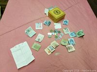 Photo showing all foreign banknotes, coins, and yellow storage box on a pink surface.