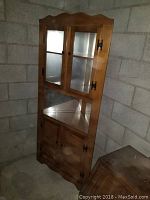 Full view of the vintage wooden corner cabinet including upper glass doors and lower wooden doors, showing condition and design.