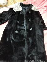 Front view of black vintage winter jacket with light faux fur collar.