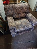 Front view of brown marbled upholstered armchair on casters