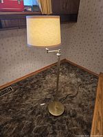 Full view of brass floor lamp with shade and base