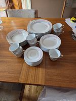 Full view of stacked plates, bowls, cups and saucers on table