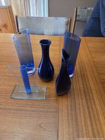 Five blue glass vases grouped on table