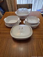 Front view of all CorningWare casseroles and lids on table