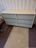 Front view of pressed wood dresser showing six drawers, white top, grey fronts
