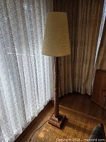 Full view of wooden floor lamp with shade in room