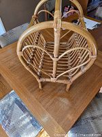 Overall view of bamboo and rattan magazine rack showing front lattice and handle