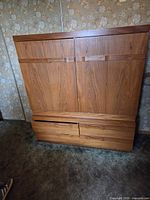 Front view of closed teak tallboy cabinet