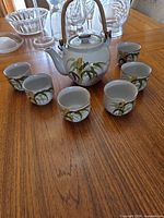 Full tea set on table showing teapot and six cups