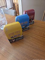 Three Star Trek DVD sets in yellow, blue, red cases on table