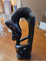 Front view of dark wooden lovers sculpture on table