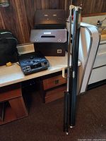 Projector, carrying case, folded screen with tripod poles