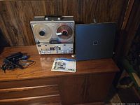 Reel-to-reel recorder, speaker panel, microphone cable, manual on dresser
