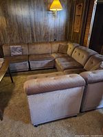 Overall view of assembled sectional sofa against paneled wall showing corner and straight units