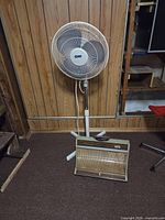 Pedestal fan standing with heater placed in front