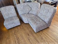 Three-piece paisley sectional arranged together on wood floor