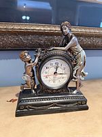 Front view of Crosa quartz figural mantel clock showing dial and full sculpture