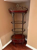 Full view of corner etagere showing metal frame, shelves, drawer