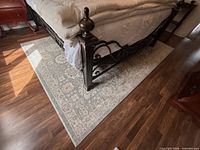 Full view of rug placed under bed showing overall size and pattern