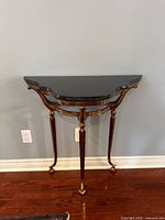 Front view of demi-lune console table showing marble top and leg structure