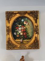 Front view of painting showing floral image and ornate gilt frame