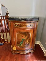 Front and side view of bombe cabinet showing marble top, painted panel, ormolu mounts