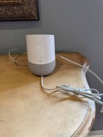Front view of Google Home smart speaker with attached power cable