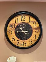Front view showing entire 30" round wall clock with black frame and rustic face