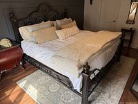 Full view of king metal bed frame with linens