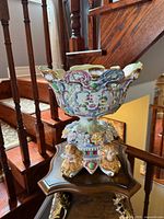 Front view of ornate Limoges porcelain centerpiece bowl showing floral relief, cherubs and gilt accents