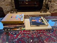 Side view of stacked cookbooks on glass table