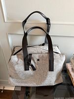Front view of heathered grey Lululemon Go Better Bag with black handles