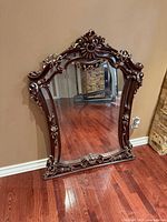 Front view of ornate carved wood mirror