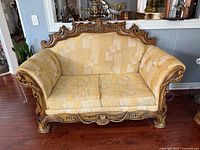 Front view of carved wood loveseat