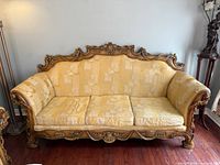 Front view of carved wood sofa, cushions in place
