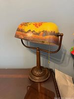 Front view of lamp showing painted glass shade and base