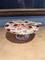 Top view of floral pedestal cake plate with server resting on it