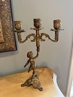 Full view of brass 3-arm candelabra on table