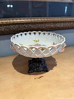 Full view of porcelain bowl on metal pedestal showing lattice rim and floral design