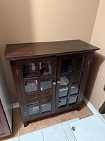Front view of cabinet showing glass doors and knobs