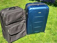 Blue hard-shell and black soft-sided suitcases side by side
