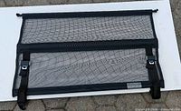 Flat view of cargo net with straps and clips
