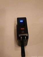 Front view showing LED charge display, USB-A and USB-C ports, folding plug tip extended