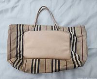 Front view of tote showing leather pocket and striped canvas