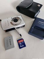 Camera, battery, charger, SD card, leather case