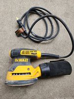 Side view of DeWalt DWE6423 sander with cord and dust bag