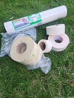 Lot overview with Wall Doctor fabric, fibreglass mesh tapes in bag, three paper drywall tape rolls