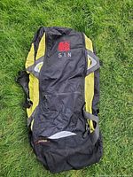 Front view of black and yellow Gin rucksack showing logo and pockets